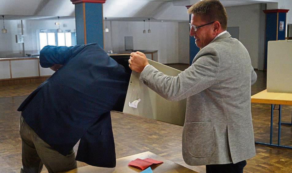 Mit vollem Körpereinsatz fischte Herbert Stratmann einen Wahlzettel, der sich in der von Wahlleiter Guido Holzdeppe gehaltenen Urne verhakt hatte, heraus. Foto: philip Stallmeister