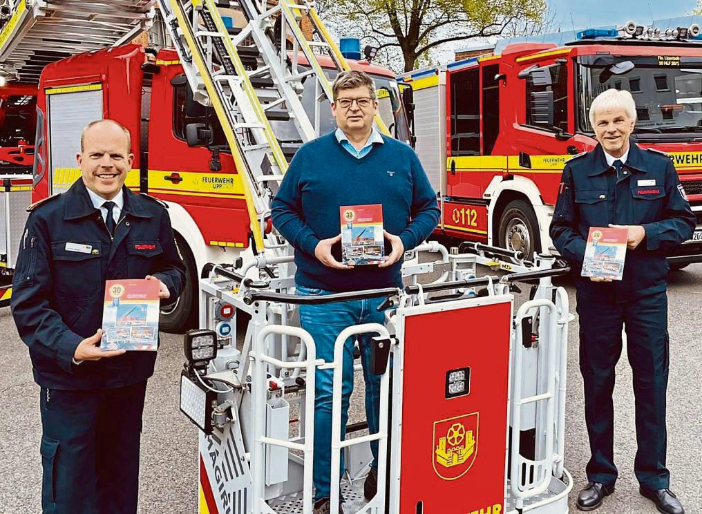 Einsatzfahrzeuge der Feuerwehr Lippstadt auf 128 Seiten: Autor André Streich (M.), Reinhard Falkenstein (Vorsitzender des Stadtfeuerwehrverbandes) und Wehr-Chef Christian Meyer stellten das Buch zum 30-Jährigen des Stadtfeuerwehrverbandes vor. Foto: Feuerwehr Lippstadt