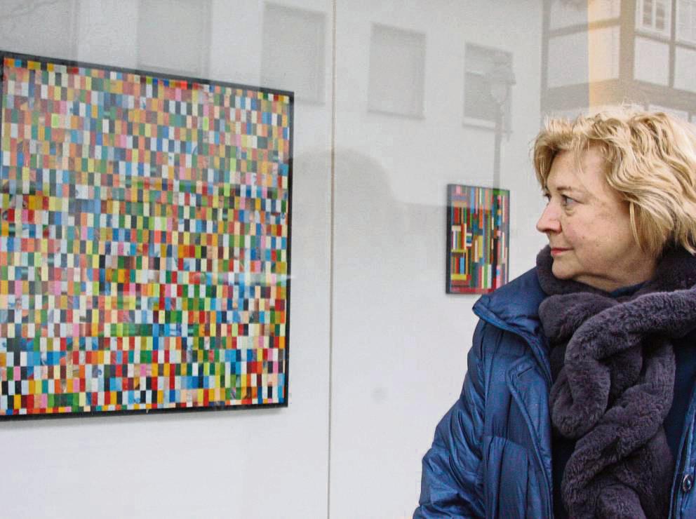 Die Künstlerin Gabriele Wilpers vor der Fensterfront am Hellweg. Im Glas spiegelt sich ihr schräg gegenüber liegendes Elternhaus. Zu sehen sind derzeit Arbeiten des Autodidakten Ulrich Kurze. Fotos: Helga Wissing