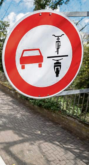 Rotes Auto, schwarzes Fahrrad und ein motorisiertes Zweirad auf weißem Grund: Verkehrszeichen 277.1 – das Schild gibt es seit 2020 – regelt das Überholverbot von einspurigen Fahrzeugen. Foto: dpa