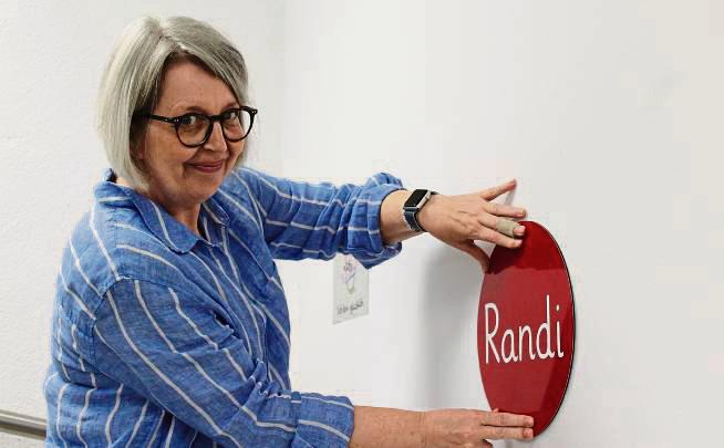 Schulleiterin Eike Buttermann bringt neue Schilder zur Orientierung an. Foto: Mintert