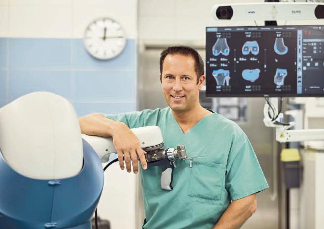 Marc K. Schuler mit dem Mako-OP-Roboter. Mittels dieser Technologie werden millimetergenaue Planung und deren exakte Umsetzung möglich.