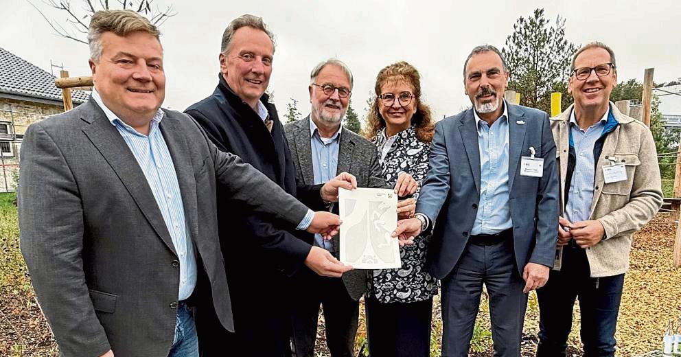 Da ist das Ding! Thomas Sommer (2.v.l) von der Bezirksregierung Arnsberg überreichte den Förderbescheid an (v.l.) Lippstadts Bürgermeister Arne Moritz, Joachim Drüke (Abu), Carmen Harms (KWL) und Matthias Lürbke (Bürgermeister Lippetal). Auch zur Freude von Hubertus Winterberg, Geschäftsführer der Südwestfalen Agentur. Foto: Ursula Vielberg