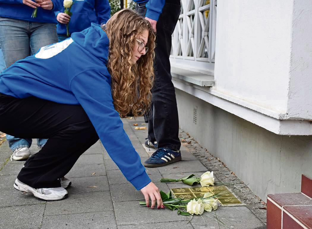 Sieben weiße Rosen legten die Schüler an den Stolpersteinen für die Familie Cohn/Schiff in der Cranestraße 42 nieder. Foto: Daniel Kossack