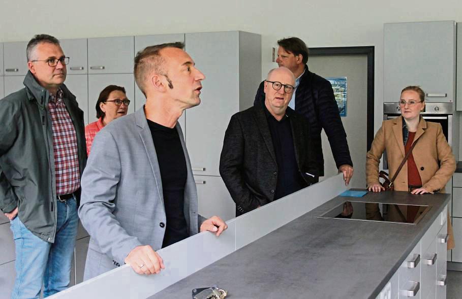 Der kommissarische Schulleiter Marcus Schiffer (3.v.l.) beendete seine Schulführung für die Mitglieder des Bildungsausschusses in der nagelneuen Schulküche der Sekundarschule. Die Politiker zeigten sich begeistert über die Ausstattung. Foto: Raestrup