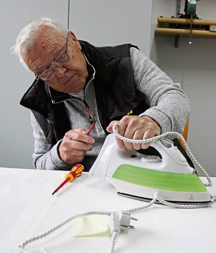 Gar nicht so einfach: Manfred Nölle tauscht das Kabel eines Bügeleisens. Foto: Löseke
