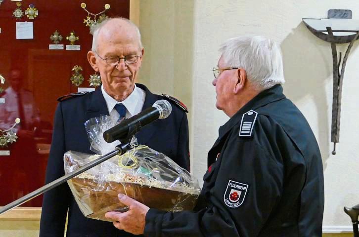 Unter großem Applaus überreichte Stadtbrandmeister i.R. Uli Schiwek (r.) einen liebevoll gestalteten Präsentkorb. Bewegt bedankte sich Norbert Sandmeyer (l.). Foto: Dreier (Feuerwehr)