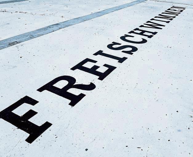Die Künstler pinselten das Wort „Freischwimmen“ auf den Boden des 50-Meter-Beckens.