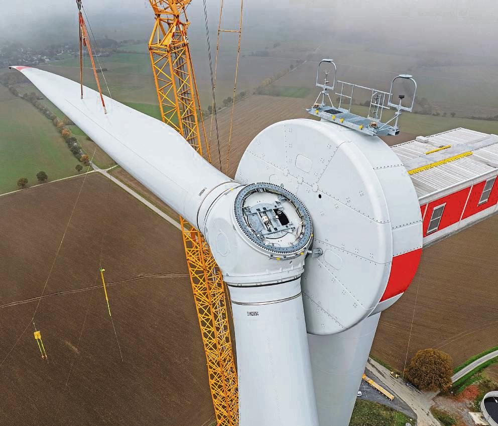 Mit einem Spezialkran wurden die Flügel der Windräder an der Spitzen Warte installiert. Unter den tiefen Wolken schemenhaft erkennbar: Menzel. Foto: Bernd Eickhoff