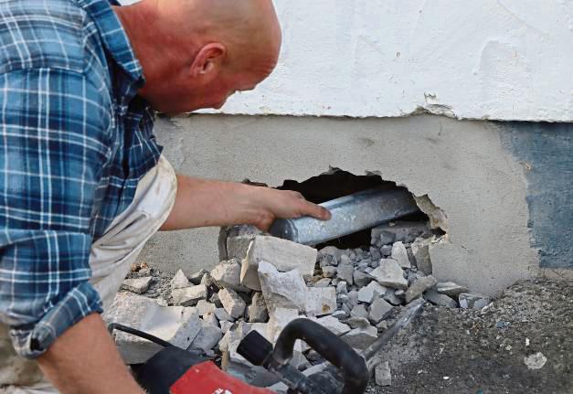 Mit einem Bohrhammer stemmte ein Bauarbeiter die Zeitkapsel im Betonsockel der Schule frei.