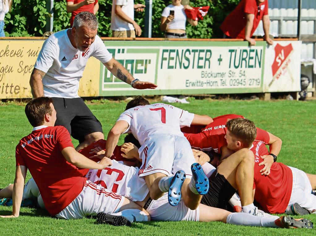 Jubeltraube, und Trainer Jörg Dier (l.) ist mittendrin: In der 92. Minute sorgte Horns Yannick Wulf (verdeckt) mit dem 2:0 für die endgültige Entscheidung. Foto: Feichtinger