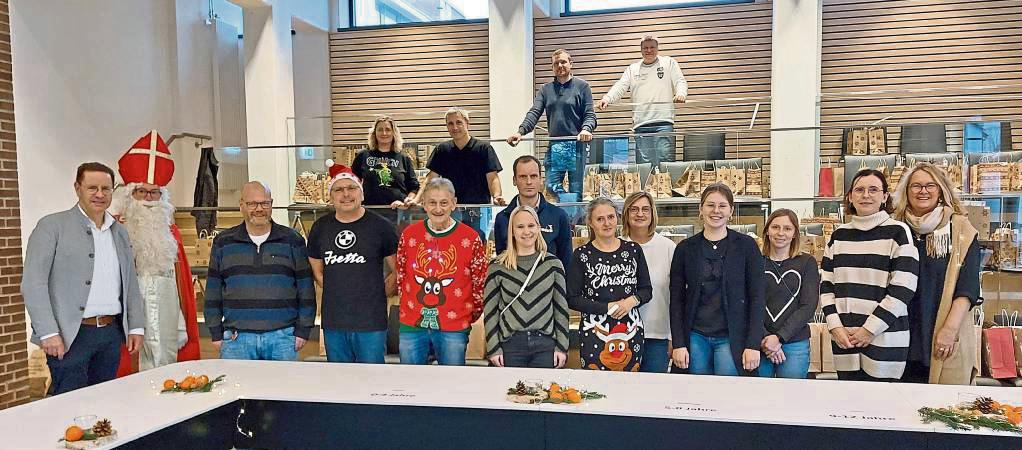 Bürgermeister Ulrich Berger (vorne links), der Nikolaus und die Mitarbeitenden vom Fachbereich Bildung und Soziales warten im Ratssaal auf die Familien.