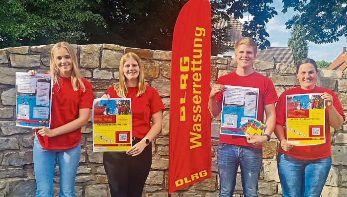 Die DLRG-Mitglieder (v.l.) Marie Wenge, Linda Sander, Maximilian Sander und Vanessa Biermann präsentieren ihre Plakate und Flyer für die Sommersaison. Foto: DLRG