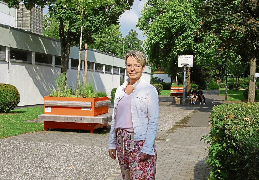 Zwischen Dreifachsporthalle und Jugendtreff soll der neue Treffpunkt / Lounge-Bereich entstehen. Bauamtsleiterin Birgit Hendriks erläutert vor Ort, was alles geplant ist. Foto: Meschede