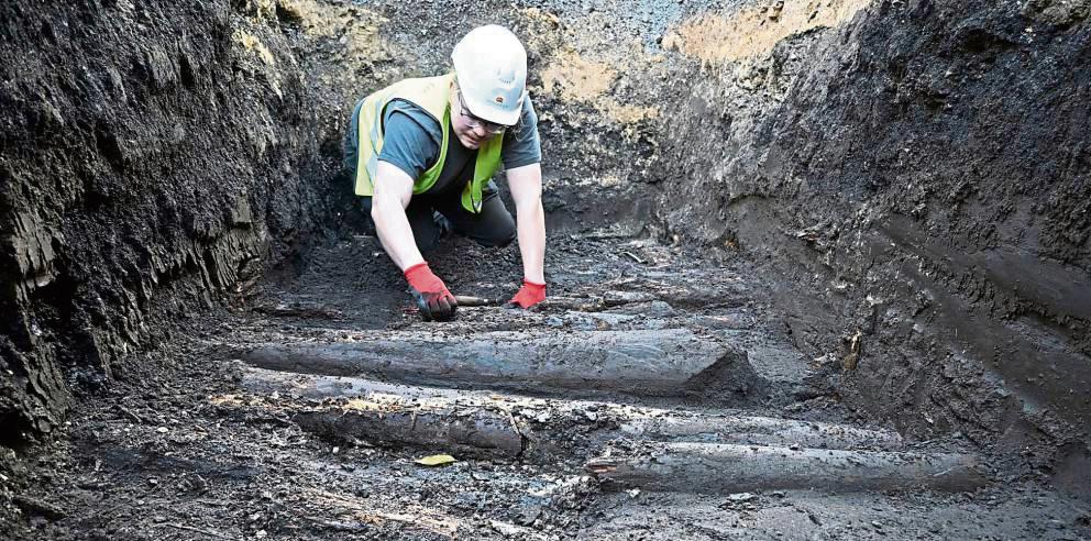 In 1,50 Meter Tiefe legt der Archäologe Philipp Rethwisch den mittelalterlichen Bohlenweg unter der Langen Straße in Rietberg frei. Foto: LWL-AfW/S. Spiong