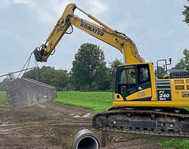 Wasser marsch in die Mersch: Hier wird mit dem Bagger ein Wehr-Teil zum Einbauort transportiert. Foto: Petra Salm