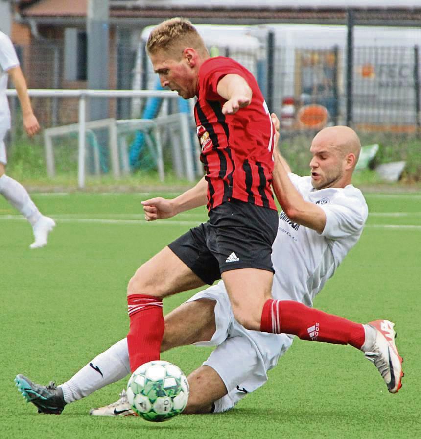Kornel Toth (rotes Trikot) und der SV 03 Geseke halten die Klasse, und das am vorletzten Spieltag. In Delbrück siegten sie 1:0. Foto: Heinke