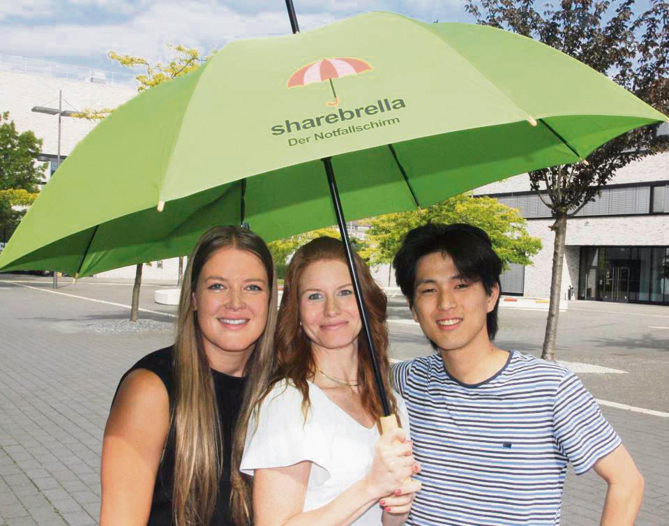 Die Leih-Regenschirme („Sharebrella“) sollen im Oktober in der Lippstädter City verfügbar sein. Das hoffen (v.l.) Anna Vanbrabant, Sara Massimo und Fuga Inui. Foto: Schwade