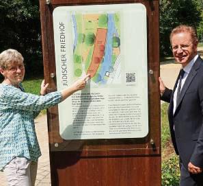 Elisabeth Kloke-Kemper (Verein Judentum in Salzkotten) und Bürgermeister Ulrich Berger neben der Stele, die Infos zum Friedhof gibt.