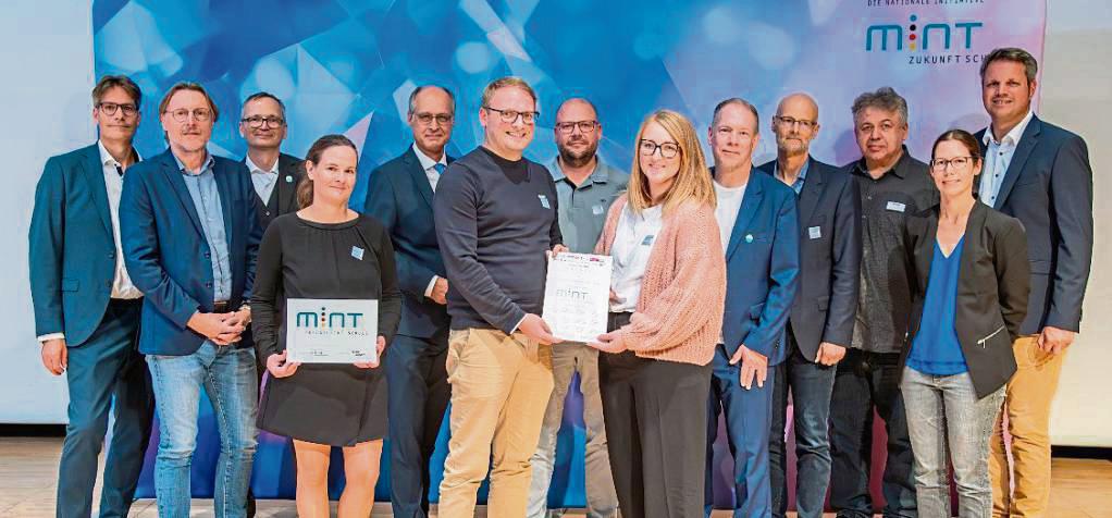Übergabe der Urkunde: Der Didaktische Leiter Patrick Dirichs (6.v.l.) sowie Tobias Siemen (7. v.l.) und Sabrina Stang (8. v.l.) nahmen die Auszeichnung entgegen.