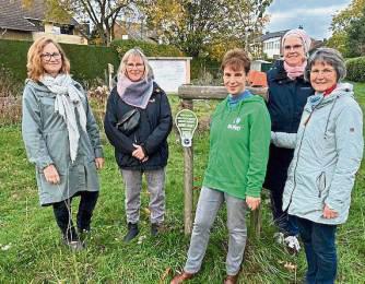 Das Foto zeigt Mitglieder des Teams vom Naturgarten Lippstadt Nord und des BUND Lippstadt/Erwitte vor dem aufgestellten Schild „Zum Schutz der vielen Arten brennt nachts kein Licht in diesem Garten“.
