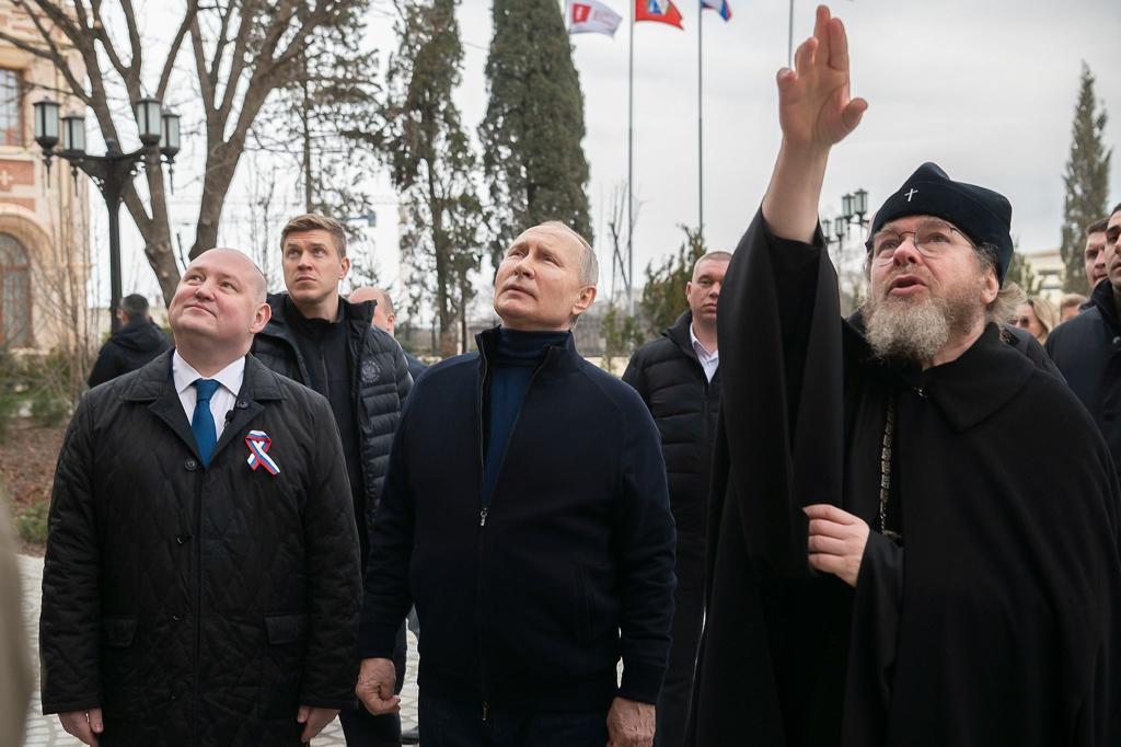 Kremlchef Putin ist zum neunten Jahrestag der russischen Annexion der Krim zu einem unangekündigten Besuch auf der Schwarzmeer-Halbinsel eingetroffen. Hier zusammen mit dem Gouverneur von Sewastopol, Michail Raswoschajew und Bischof Tichon beim Besuch einer Kunstschule für Kinder. - Foto: Uncredited/Pool Sputnik Kremlin/AP/dpa