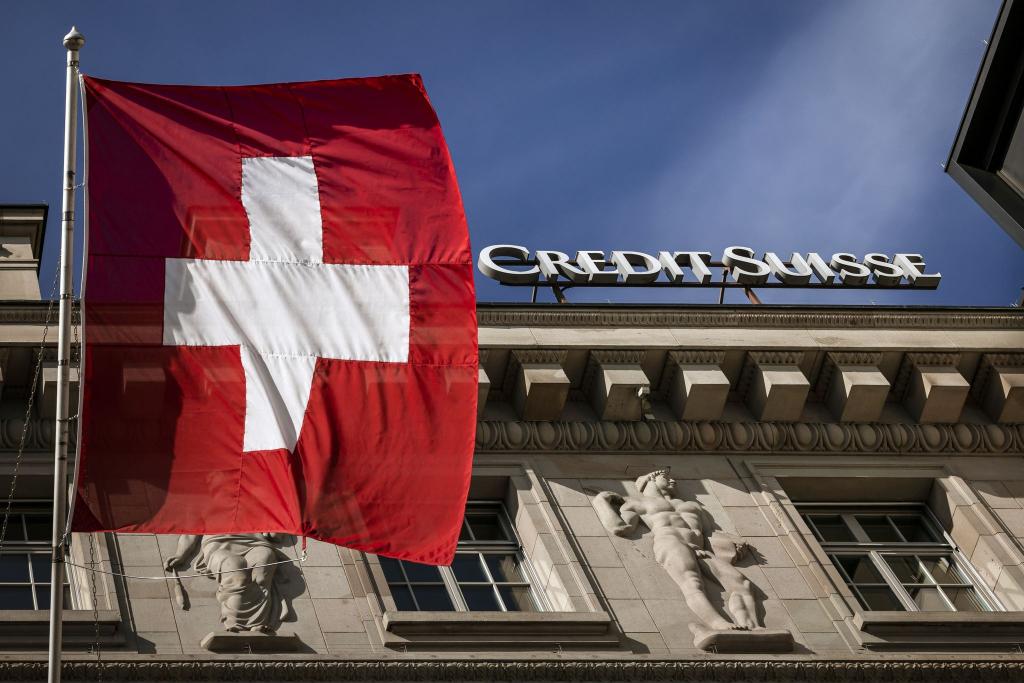 «Alle haben Angst vor dem Kollaps»: Die Flagge der Schweiz weht neben dem Logo der Schweizer Bank Credit Suisse in Luzern. - Foto: Michael Buholzer/KEYSTONE/dpa