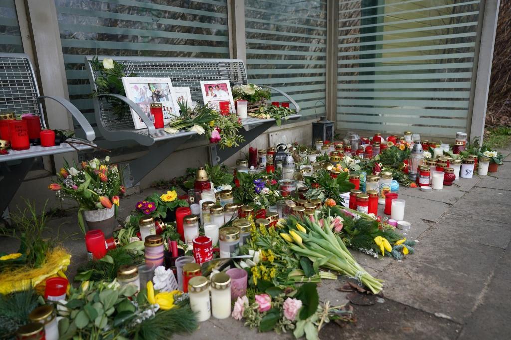 Kerzen und Blumen stehen und liegen im Bahnhof Brokstedt in einem Wartehäuschen. - Foto: Marcus Brandt/dpa