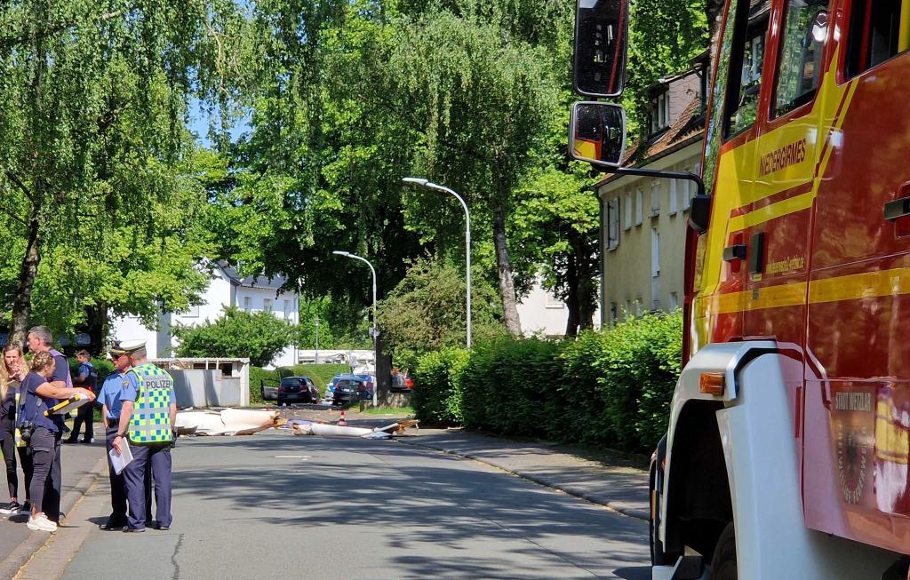 Trümmer liegen auf der Straße nach dem Absturz eines Segelflugzeugs im Stadtgebiet von Wetzlar. - Foto: Carolin Eckenfels/dpa