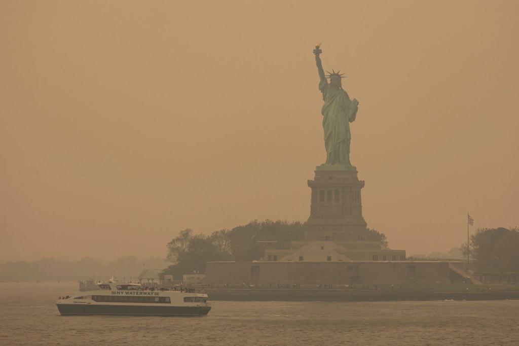 Die Freiheitsstatue ist in Dunst gehüllt. Der Rauch zahlreicher schwerer Waldbrände in Kanada hat Teile der US-Ostküste eingehüllt und in der Millionenmetropole New York für die schlechteste Luftqualität seit Jahrzehnten gesorgt. - Foto: Yuki Iwamura/AP/dpa