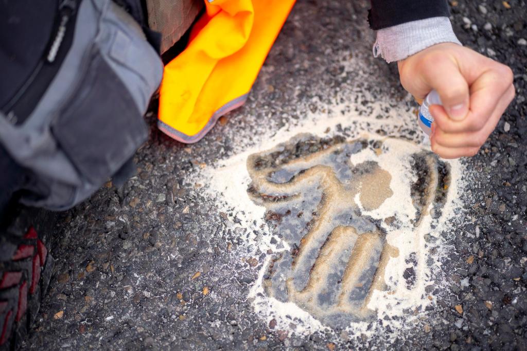 Der Handabdruck eines Aktivisten auf einer Straße. - Foto: Andreas Stroh/ZUMA Press Wire/dpa