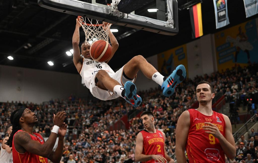 Da kommt nicht jeder hin: Der deutsche Basketballspieler Louis Olinde hängt sich bei der EM-Qualifikation Deutschland gegen Montenegro in Ludwigsburg an den Korb. - Foto: Marijan Murat/dpa
