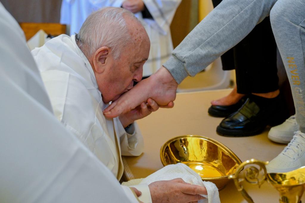 Papst Franziskus küsst den Fuß von einer weiblichen Insassin des Rebibbia-Gefängnisses. - Foto: Vatican Media/AP/dpa