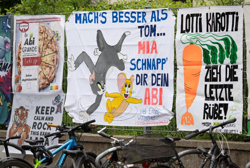 Von Freunden und Eltern gestaltete „Abiplakate“ hängen am Zaun eines Gymnasiums in Frankfurt. In Hessen starten die schriftlichen Abiturprüfungen. - Foto: Boris Roessler/dpa