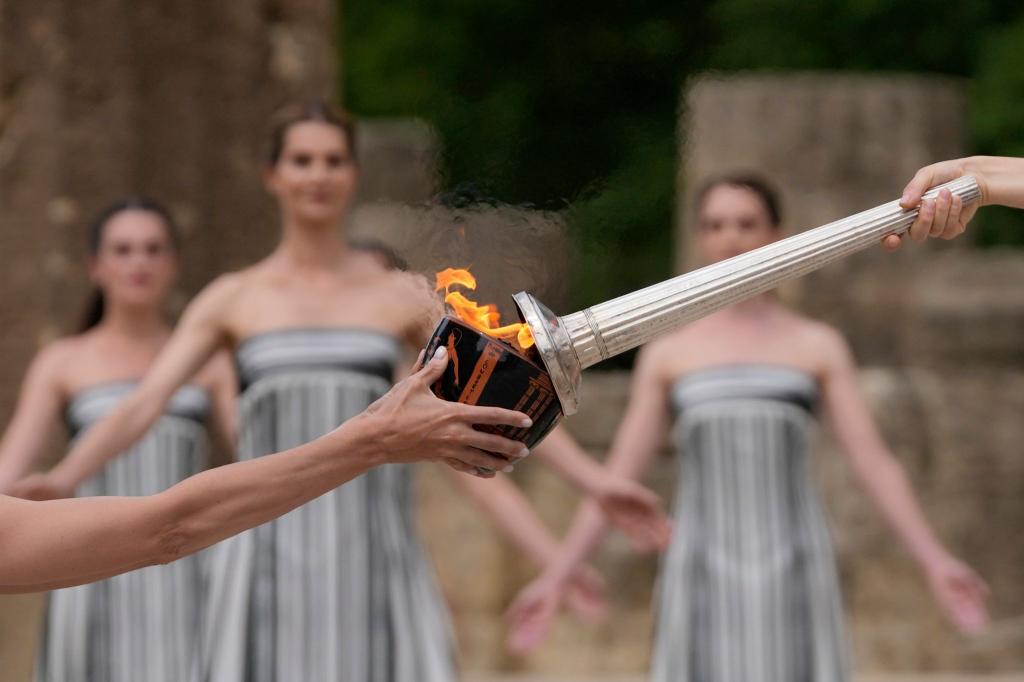 Darstellerinnen nehmen an der offiziellen Zeremonie zur Entzündung der Flamme für die Olympischen Spiele in Paris auf dem Gelände des antiken Olympia in Griechenland teil. - Foto: Thanassis Stavrakis/AP
