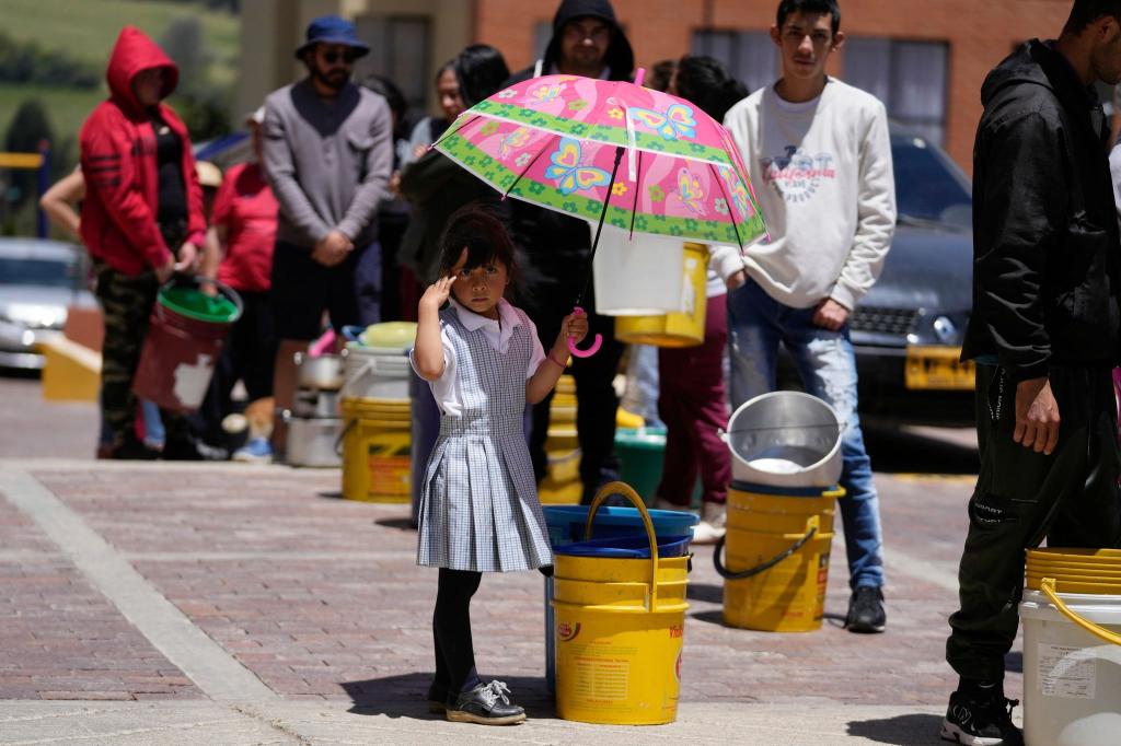 Wasserrationierung: Anwohner stellen sich in La Calera am Stadtrand von Bogota in einer Schlange auf, um Wasser aus einem Lastwagen zu holen. Angesichts der Dürre, die mit dem Wetterphänomen El Niño zusammenhängt, haben mehrere Regionen Kolumbiens Maßnahmen ergriffen, um den Wasserverbrauch zu drosseln. - Foto: Fernando Vergara/AP