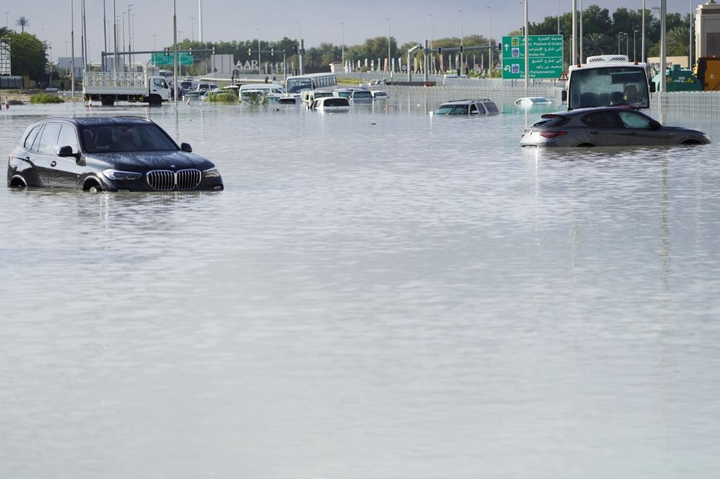 Fahrzeuge stehen verlassen im Hochwasser auf einer Hauptstraße in Dubai. - Foto: Jon Gambrell/AP/dpa