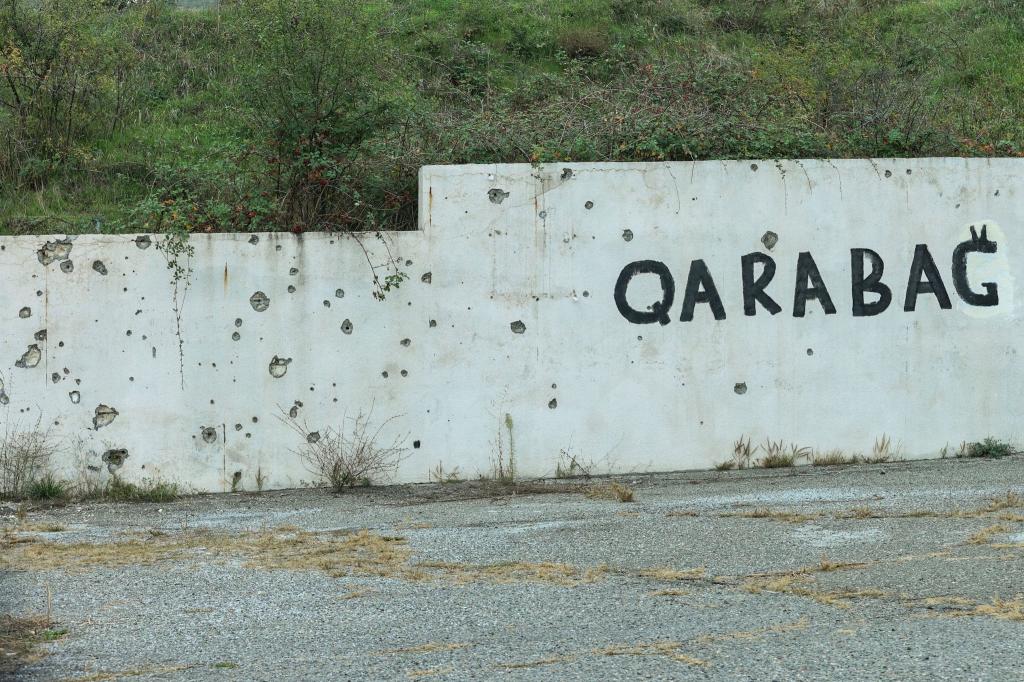 Spuren des Konflikts: Wand mit Einschusslöchern und dem Schriftzug Karabach. - Foto: Aziz Karimov/AP/dpa