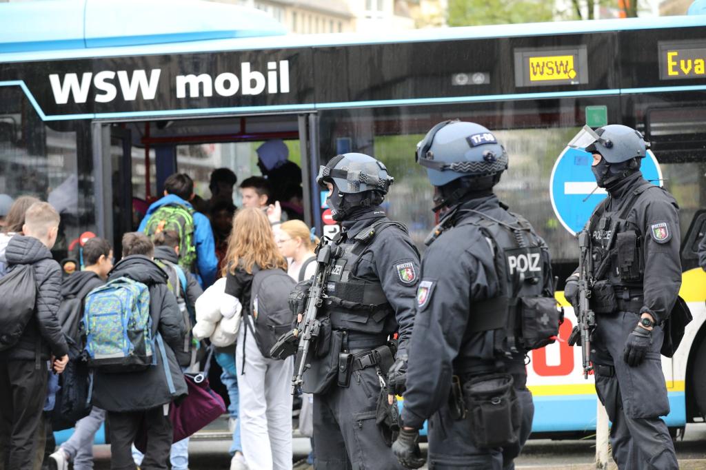 Polizisten führen Schüler in Wuppertal aus dem Gebäude in einen Evakuierungsbus. - Foto: Sascha Thelen/dpa
