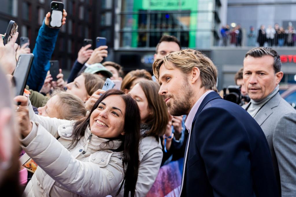 Einmal lächeln: Ryan Gosling posiert für ein Foto mit einem Fan. Der Schauspieler ist mit seiner Kollegin Emily Blunt für die Europapremiere der Actionkomödie «The Fall Guy» nach Berlin gekommen. - Foto: Christoph Soeder/dpa