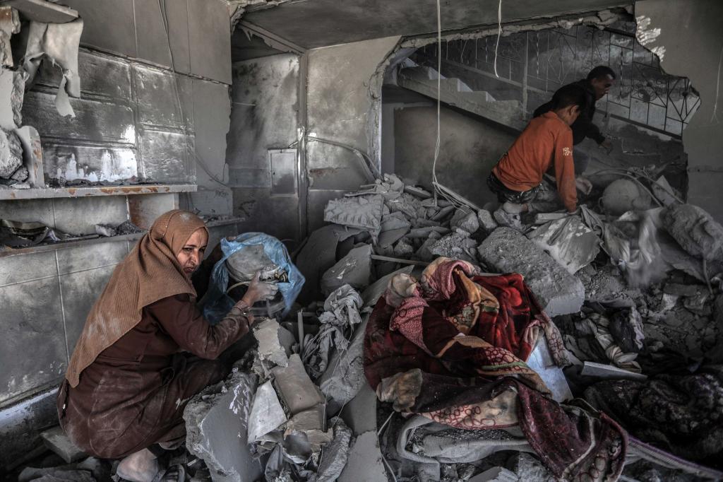 Nach einem israelischen Luftangriff such Palästinenser in einem zerstörten Haus nach Habseligkeiten. - Foto: Abed Rahim Khatib/dpa
