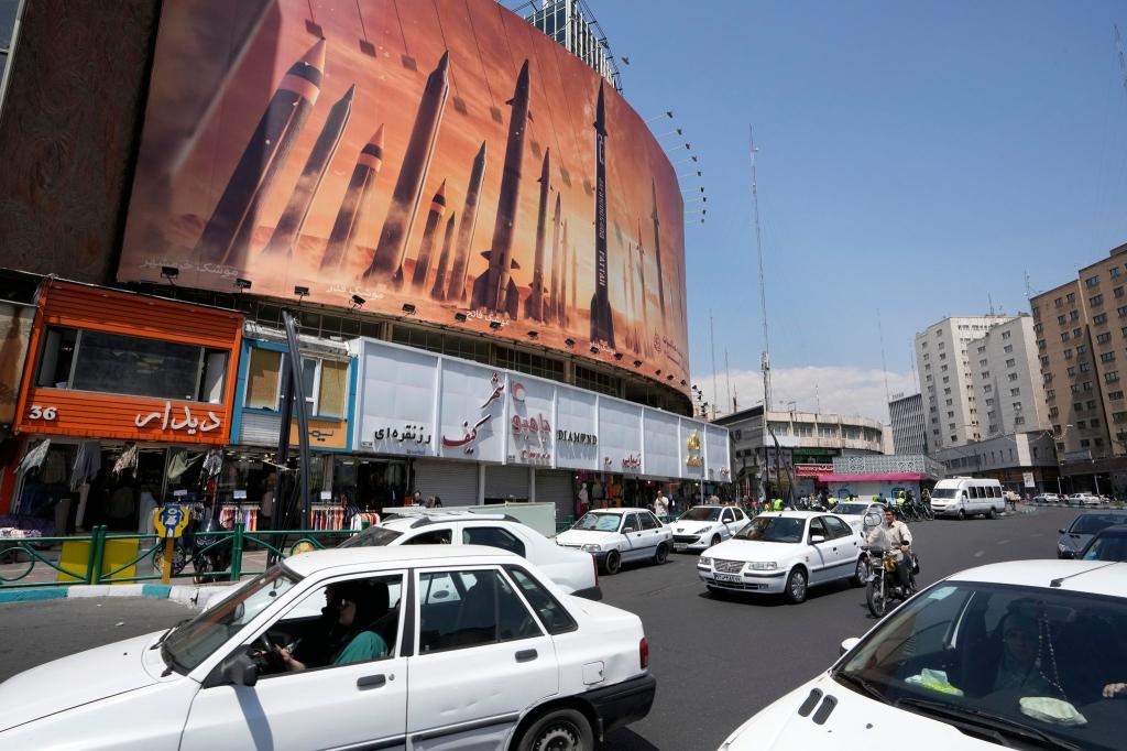 Das Zentrum der iranischen Hauptstadt Teheran mit einem anti-israelischen Transparent, das Raketen beim Abschuss zeigt. - Foto: Vahid Salemi/AP/dpa