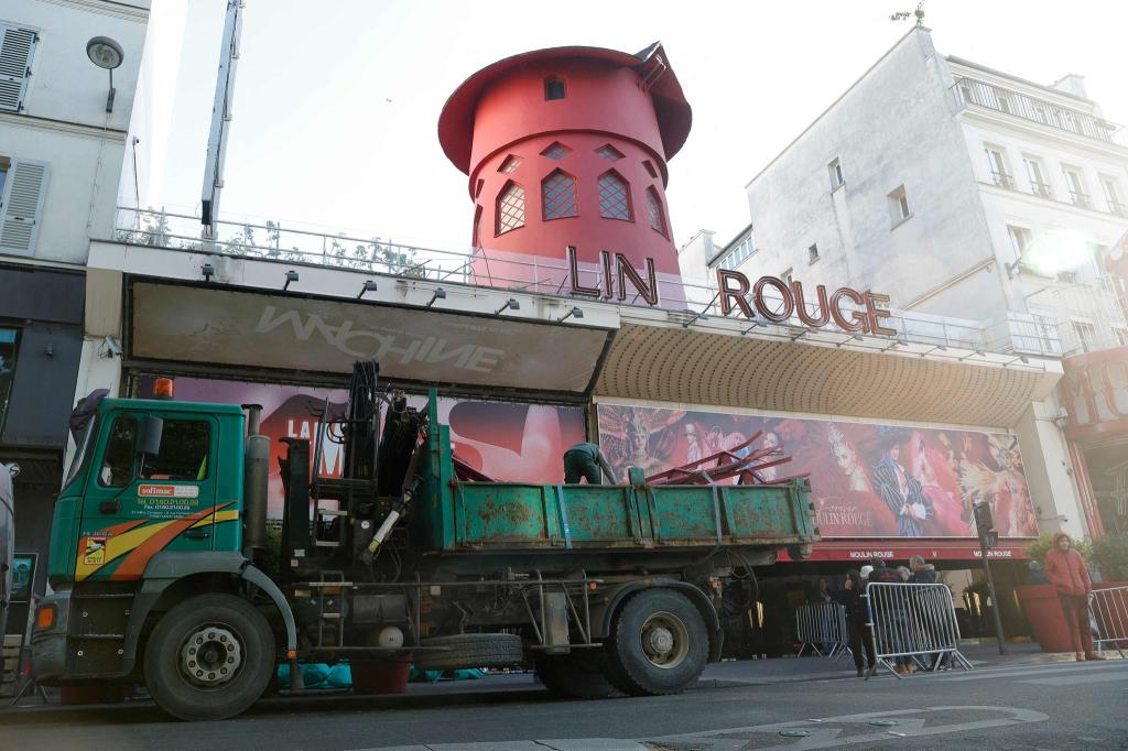 Arbeiter sichern den Bereich vor dem Kabarett, nachdem die Flügel des Windrads des «Moulin Rouge» in der Nacht abgestürzt sind. - Foto: Geoffroy Van Der Hasselt/AFP/dpa