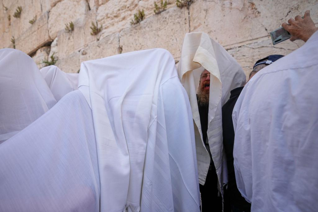 In Gebetsschals gehüllte jüdische Männer der Priesterkaste der Kohanim nehmen während des Pessachfestes an der Westmauer in Jerusalem an einer Segnungszeremonie teil. - Foto: Ohad Zwigenberg/AP/dpa