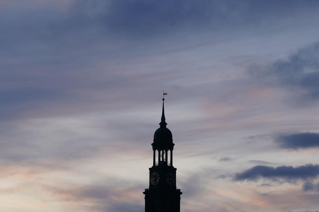 Die Turmspitze der Hamburger Hauptkirche Sankt Michaelis (Michel) ist vor dem abendlichen Himmel zu sehen. - Foto: Marcus Brandt/dpa