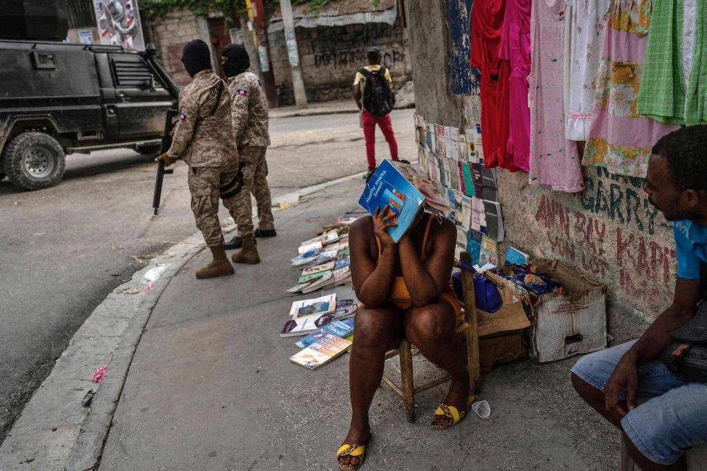 Polizisten patrouillieren neben einer Straßenhändlerin in der Innenstadt von Port-au-Prince. Bewaffnete Gruppen kontrollieren große Teile von Haitis Hauptstadt. Zuletzt eskalierte die Gewalt weiter. Mehr als 1500 Menschen wurden in den ersten drei Monaten des Jahres getötet. - Foto: Ramon Espinosa/AP/dpa