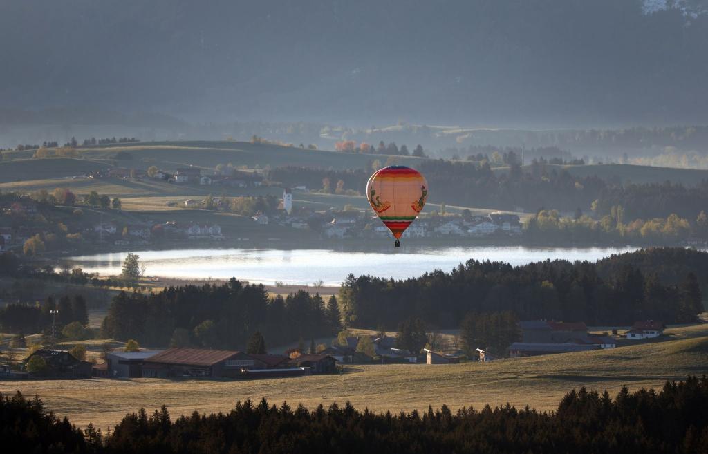 Ein Heißluftballon gleitet über den Hopfensee im Allgäu. - Foto: Karl-Josef Hildenbrand/dpa