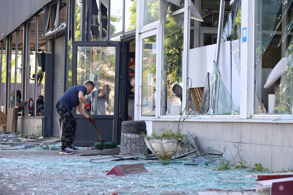 Die Spuren der Zerstörung beseitigen: Ein Mann kehrt in Odessa die Glasscherben eines Schaufensters zusammen, das bei einem russischen Raketenangriff zu Bruch gegangen ist. - Foto: --/ Ukrinform/dpa
