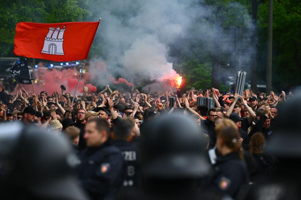 Anhänger des FC St. Pauli nehmen anlässlich des Derbys gegen den Hamburger SV an einem Fanmarsch teil. Dabei kommt auch Pyrotechnik zum Einsatz, wie auf diesem Bild zu sehen ist. - Foto: ---/dpa