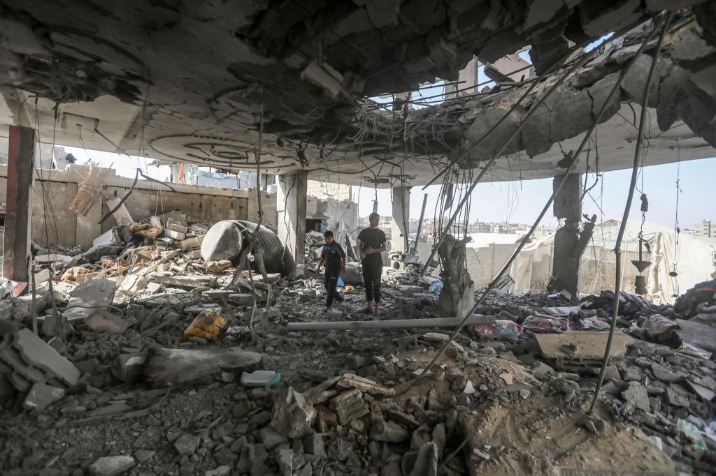 Palästinenser stehen in den Trümmern eines Hauses nach einem israelischen Luftangriff, bei dem mehrere Menschen getötet wurden. - Foto: Ismael Abu Dayyah/AP/dpa